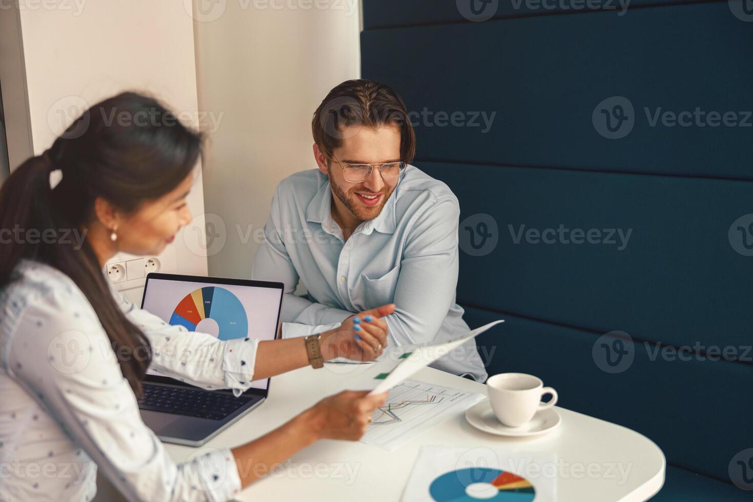 Two business colleagues working together with financial statements in stylish meeting room photo