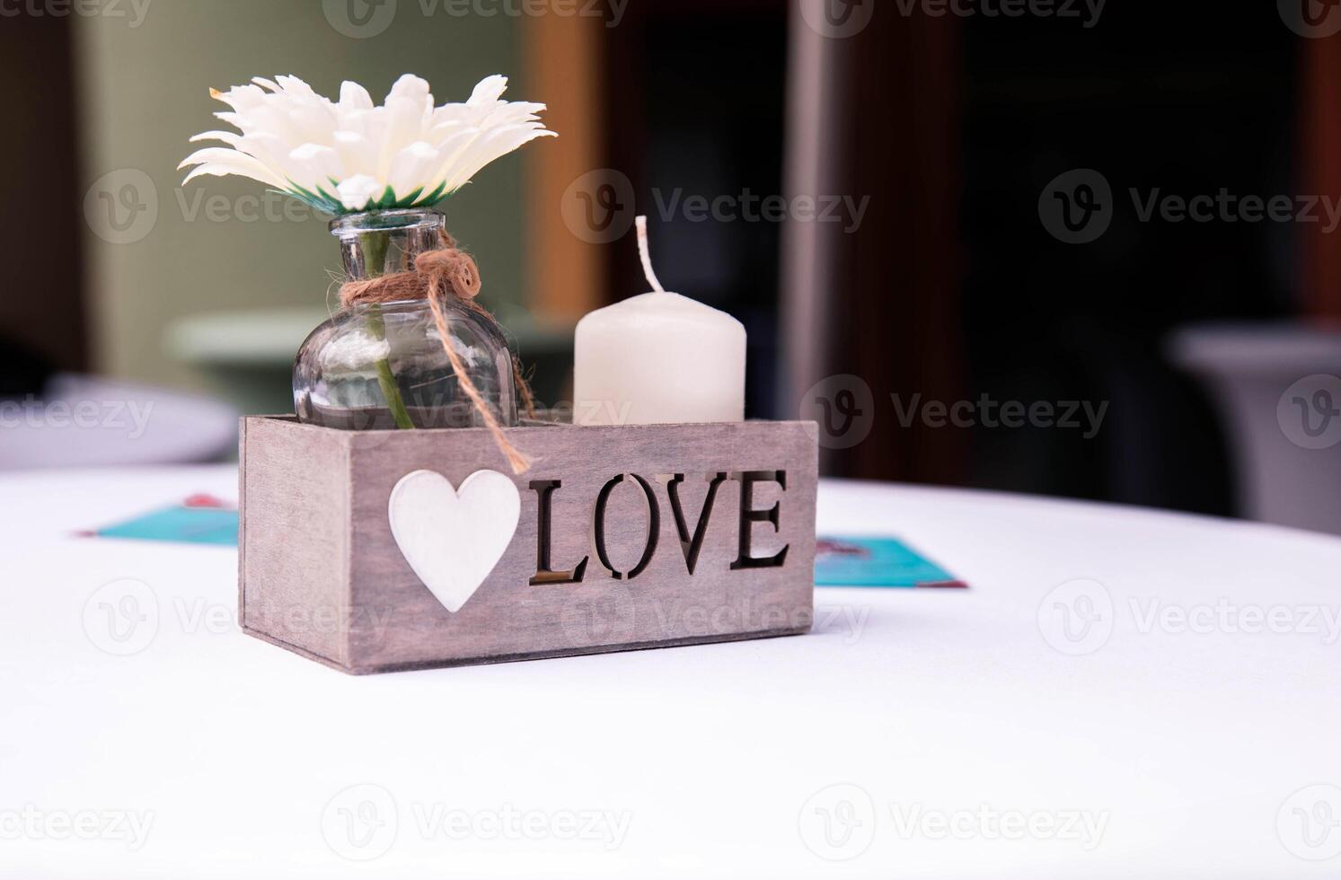 Rustic Wooden Box with LOVE Inscription and Candle on a Table photo