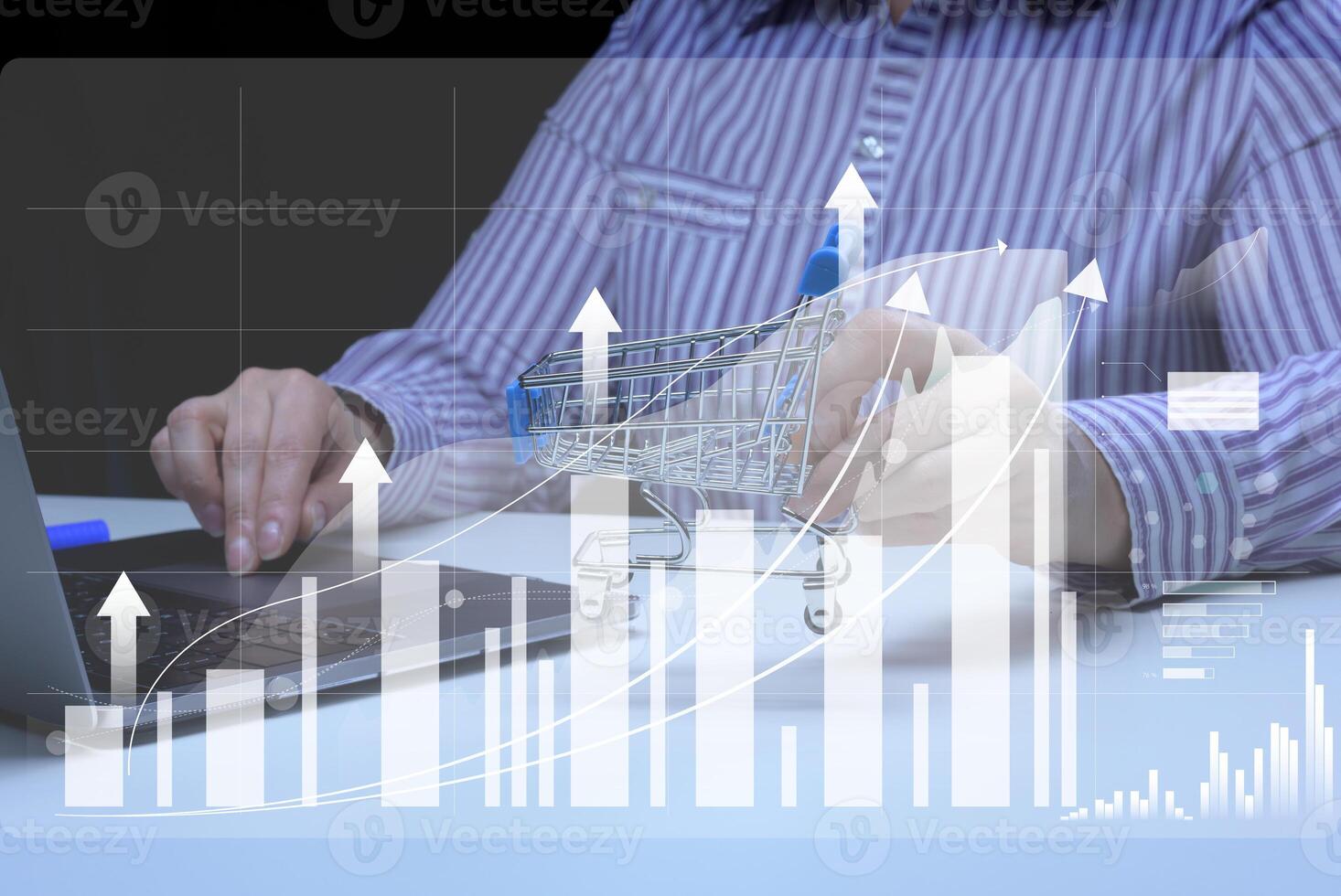 Woman sits at a laptop in front of a holographic chart with growing indicators. Business development photo