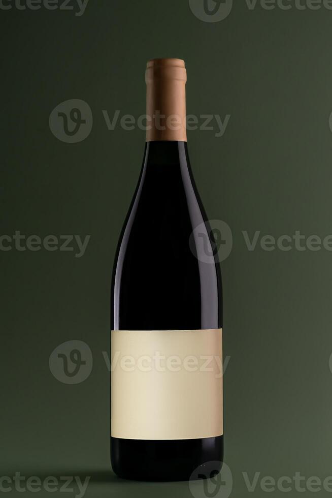 Blank red wine botte with mock up place on green background. Product, alcohol, beverage and advertisement concept photo