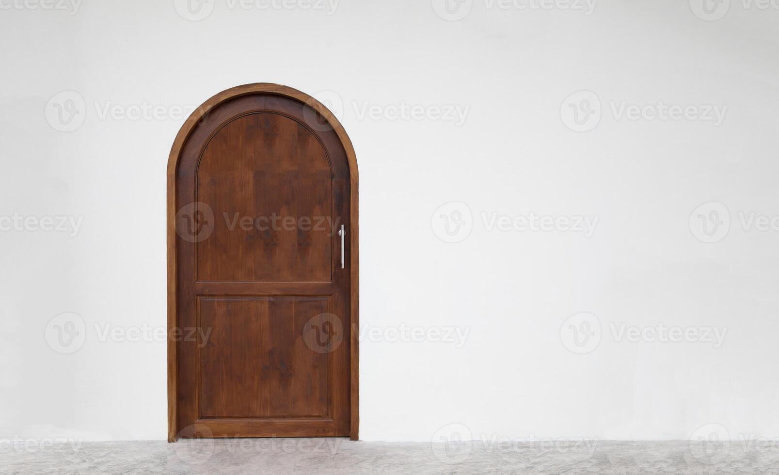Classic arched wooden door on white wall. photo
