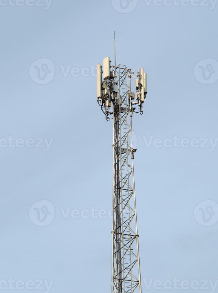 Cell phone tower on blue sky background photo