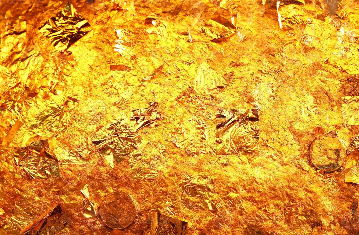 Gold leaf texture or background. Gold leaf and coin on buddha  statue. photo