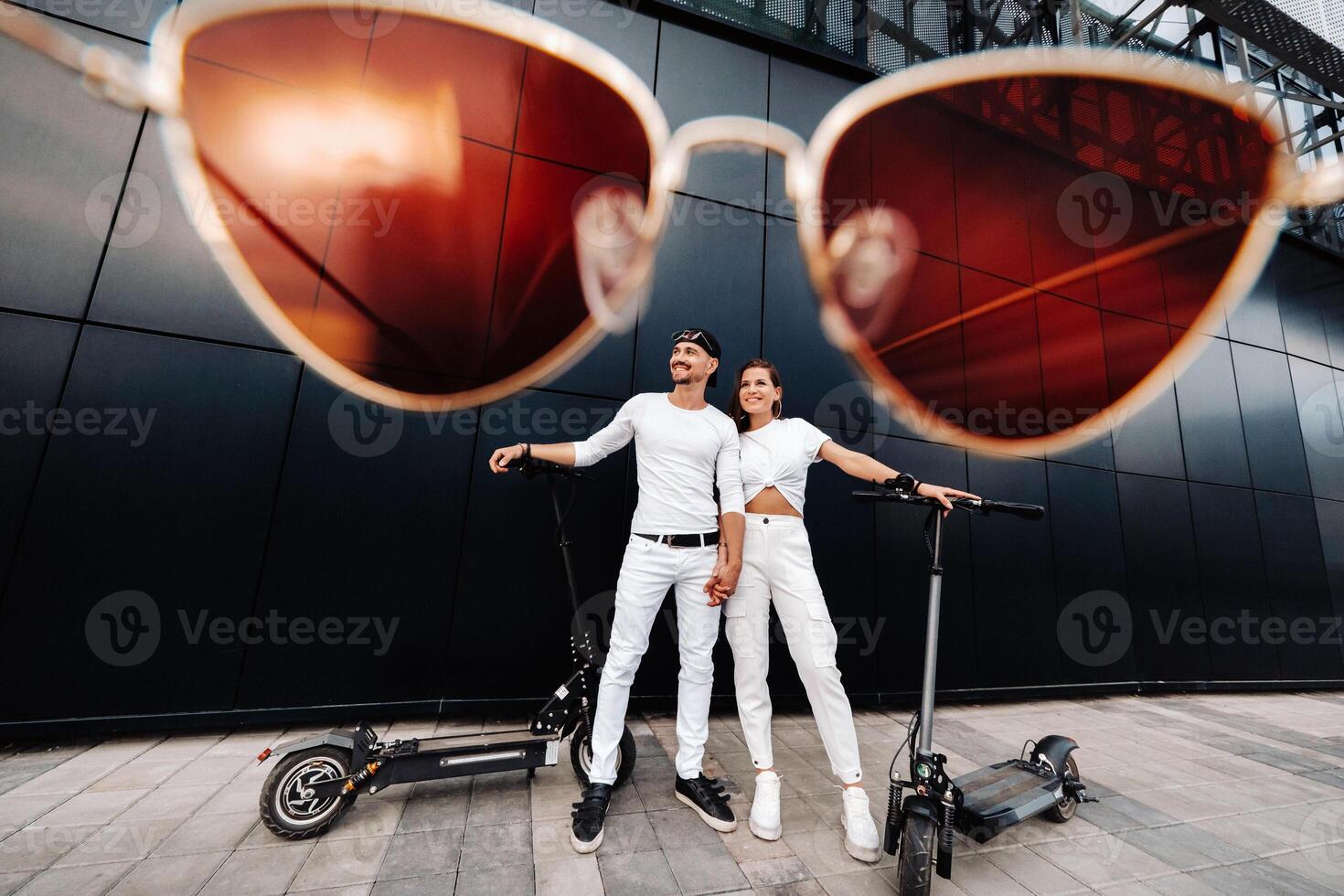 A girl and a guy are walking on electric scooters around the city, a couple in love on scooters. photo