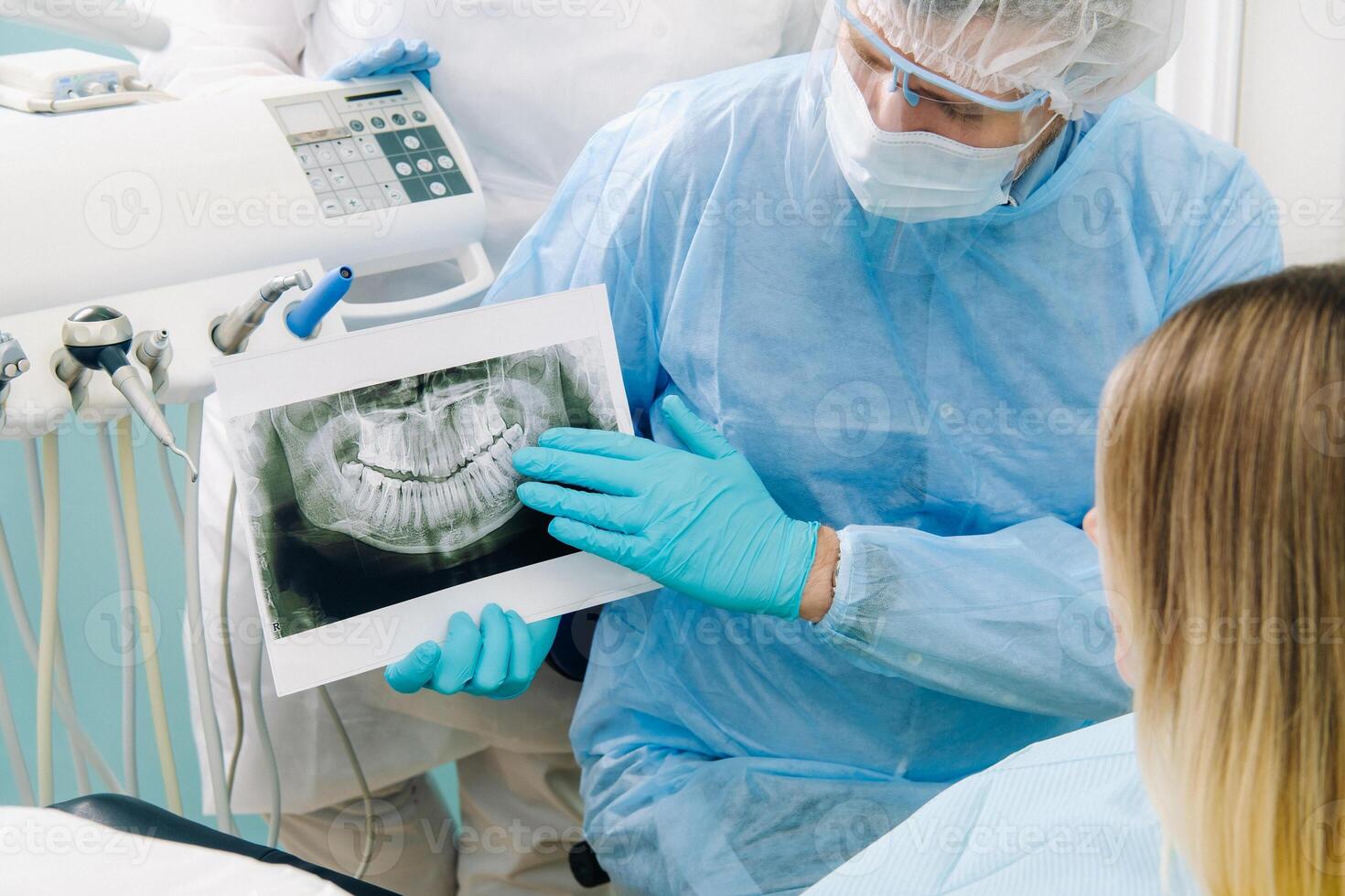 el dentista muestra el detalles de el radiografía a su paciente en el del doctor oficina foto