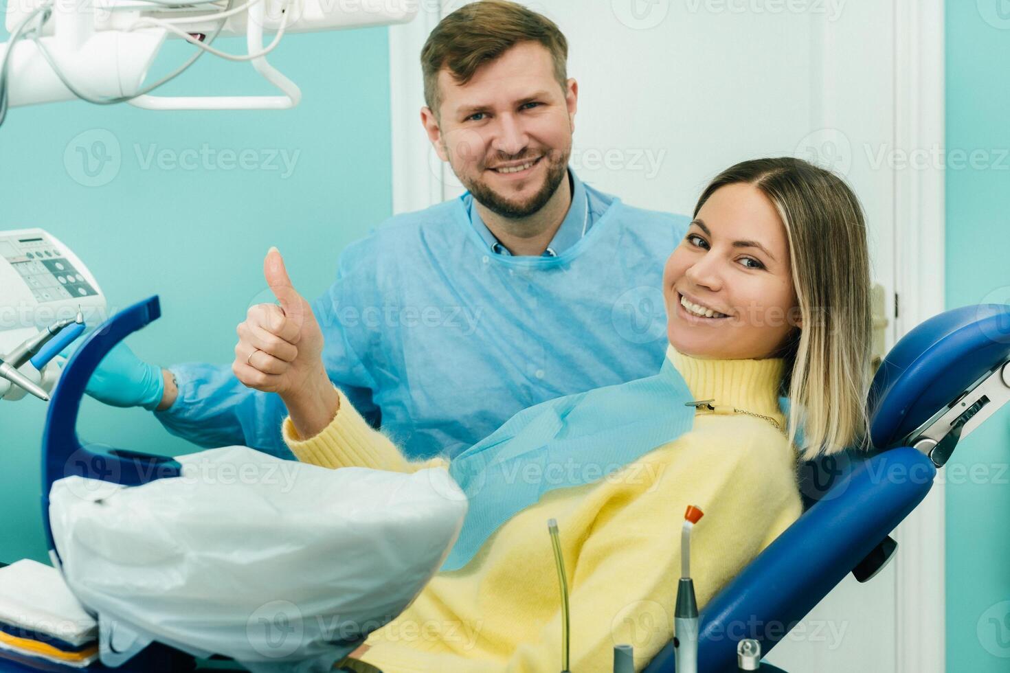 hermosa niña paciente muestra el clase con su mano mientras sentado en el del dentista silla foto