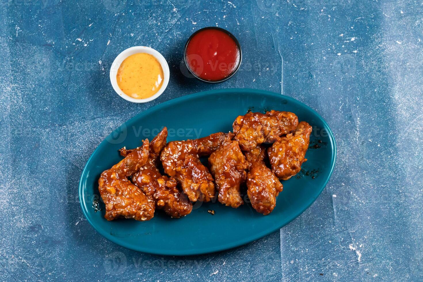 crispy chicken wings with ketchup and mayo dip served in dish isolated on background top view photo