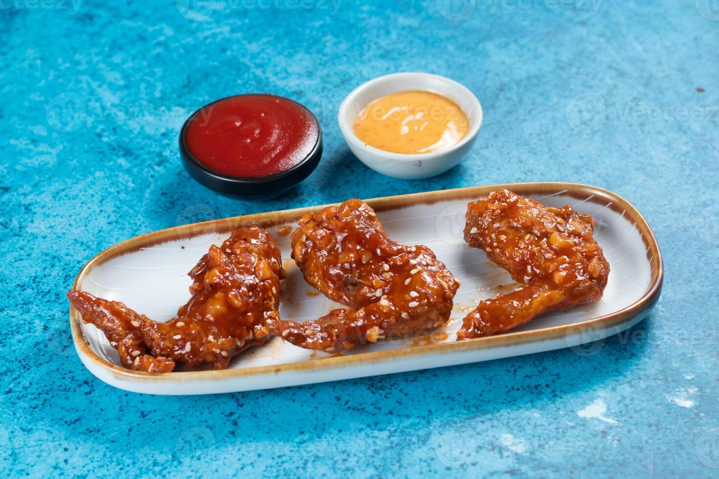 crispy chicken wings with ketchup and mayo dip served in dish isolated on background top view photo