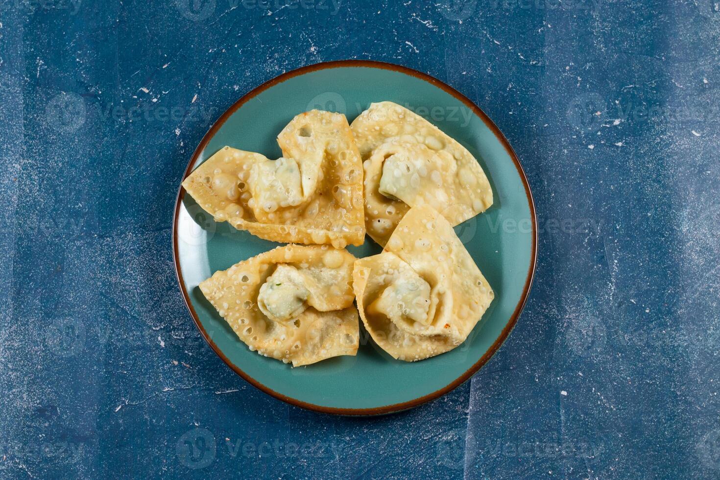 Crispy fried wonthon dim sum wraps with tomato sauce served in a dish isolaed on table top view photo