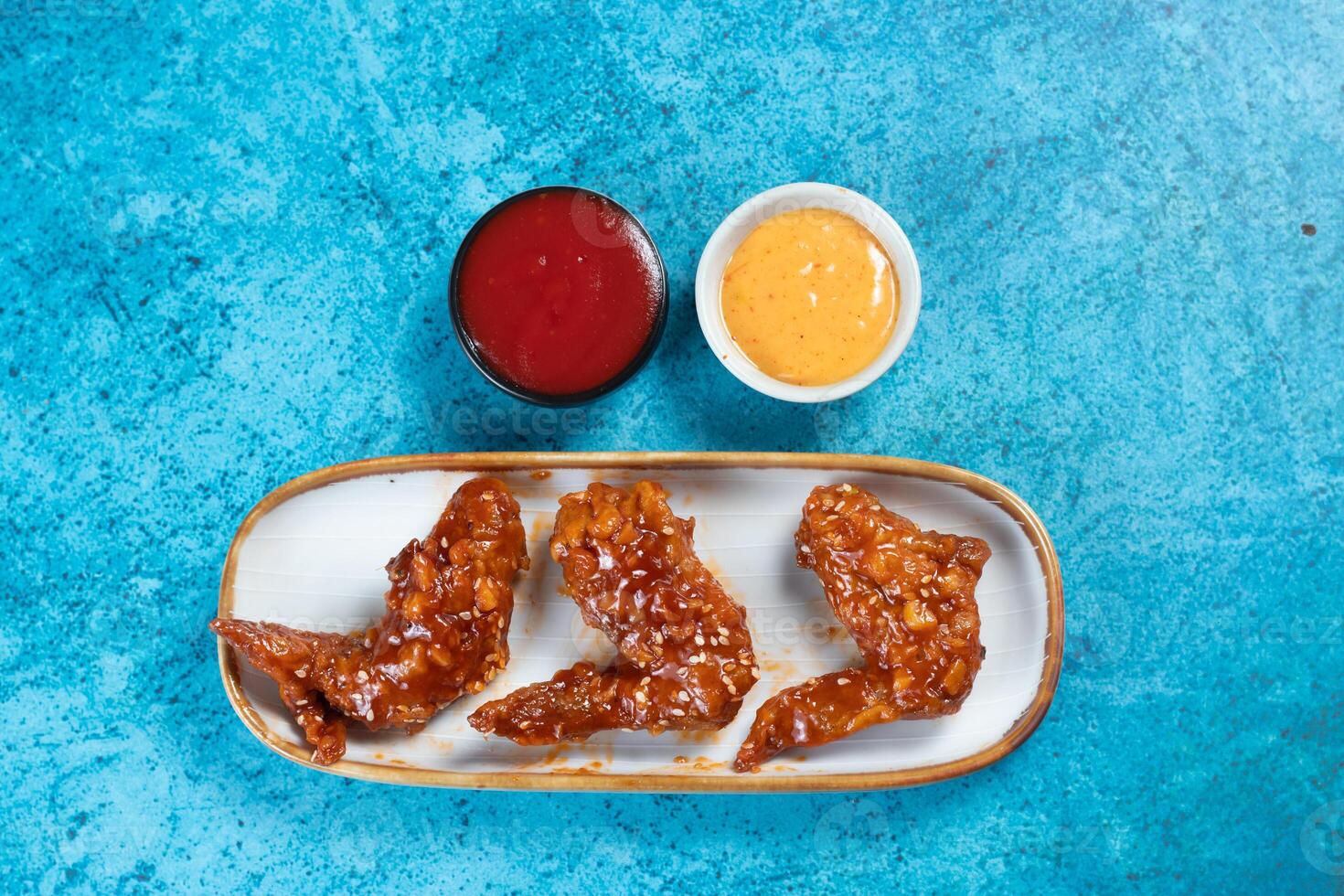 crispy chicken wings with ketchup and mayo dip served in dish isolated on background top view photo