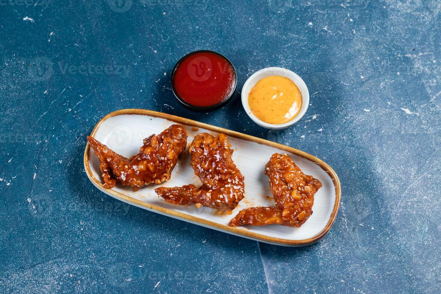 crispy chicken wings with ketchup and mayo dip served in dish isolated on background top view photo