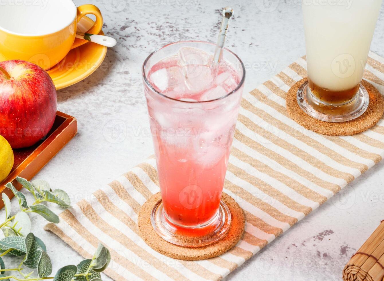 Love Sakura Sparkling Water in glass with ice cubes on mat and white background. fresh Healthy drinks concept photo