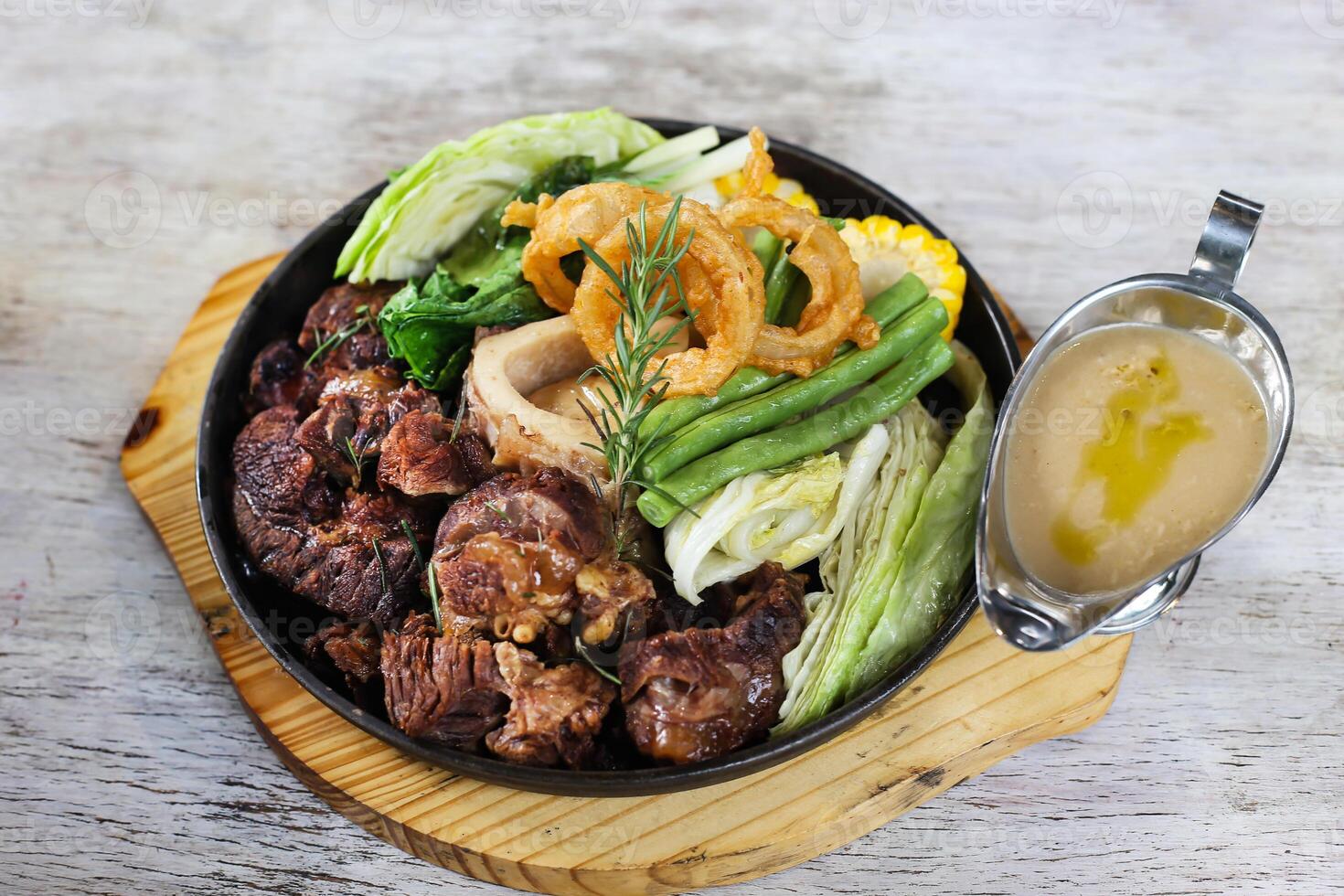 Sizzling Bone Marrow Bulalo and Truffled Mushroom Gravy served in a dish isolated on grey background side view of stewed photo