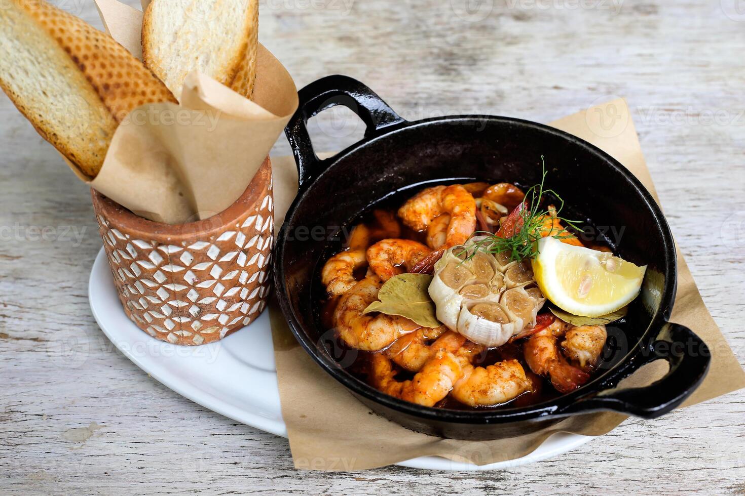 Sizzling Gambas Al Pil Pil with garlic bread served in a dish isolated on grey background side view of snacks photo