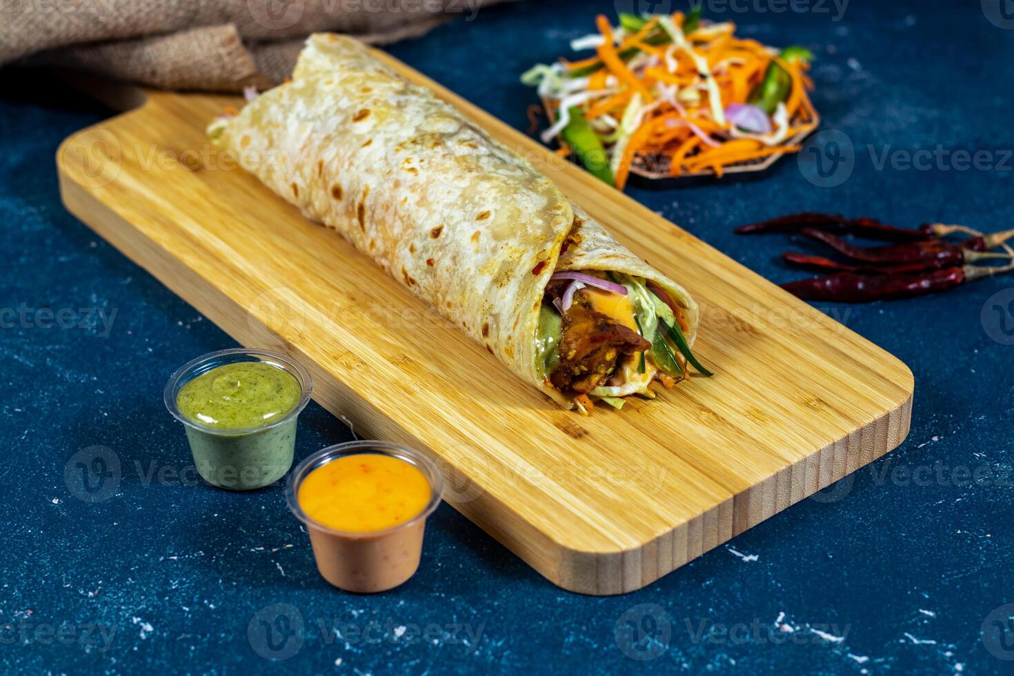 Bhuna Beef shawarma Wrap with salad dip and sauce isolated wooden board side view of fastfood photo