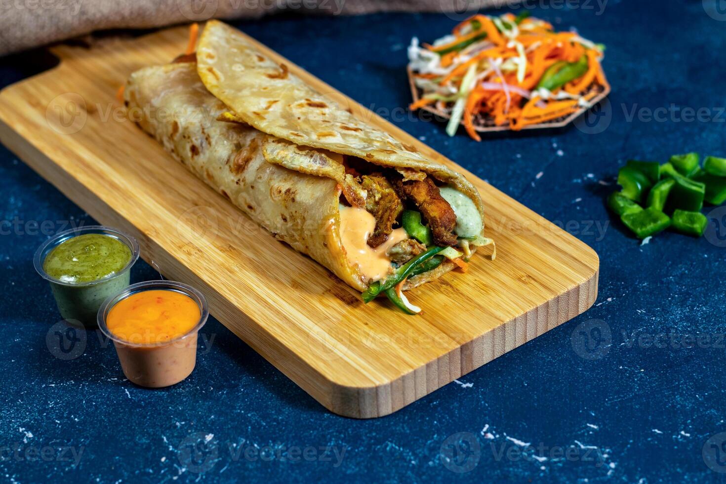 Chicken Tikka shawarma Wrap with salad dip and sauce isolated wooden board side view of fastfood photo