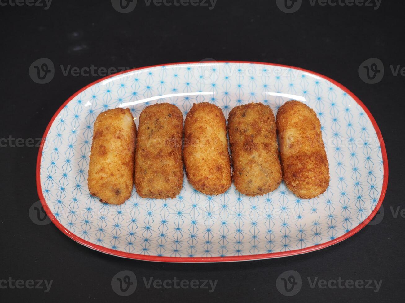 Ham and Mushroom Croquettes served in a dish isolated on dark background top view photo