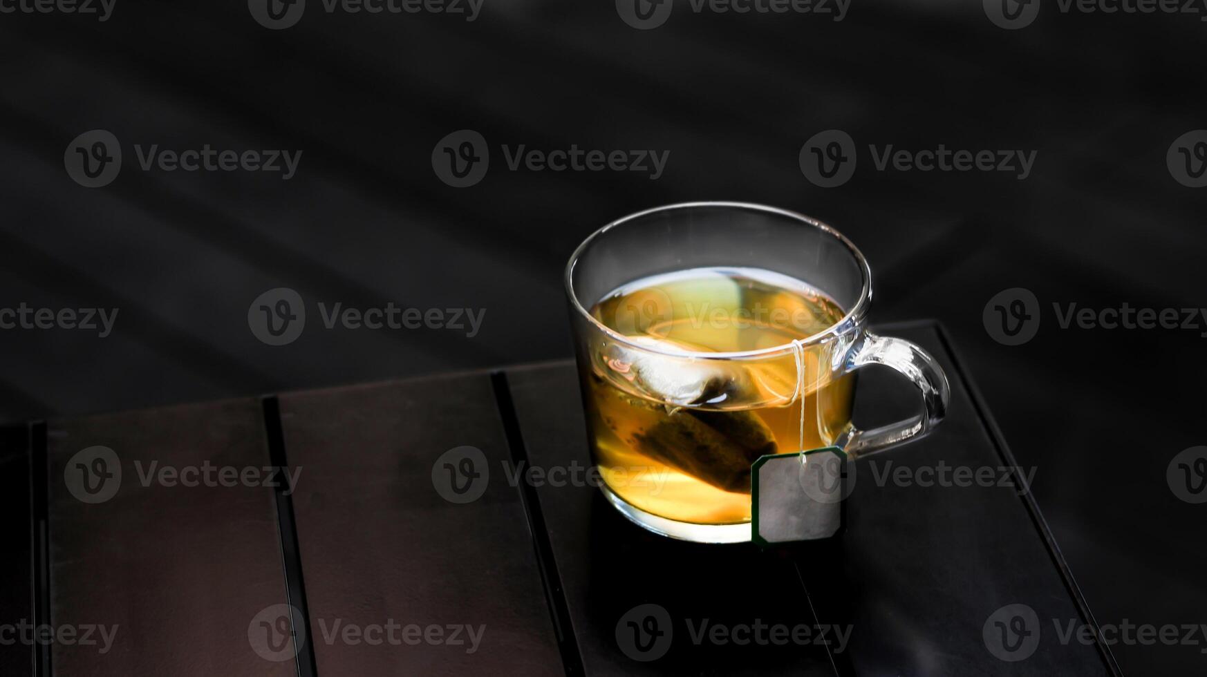 caliente jazmín verde té con té bolso servido en un taza aislado en oscuro antecedentes lado ver foto