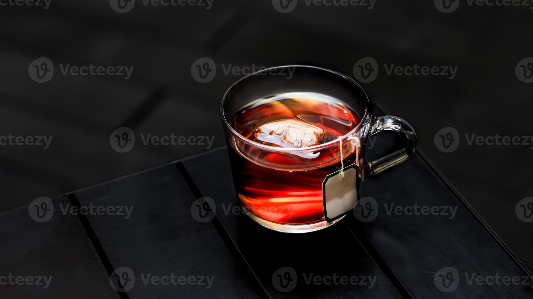 Hot Earl Grey Tea with tea bag served in a cup isolated on dark background side view photo