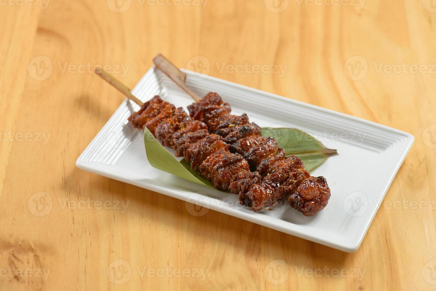 Japanese BBQ Kawa kebab sticks in a white tray on wooden background top view photo