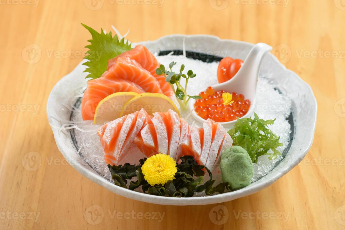 Japanese food sashimi shake platter with ice in a bowl isolated on wooden background top view photo