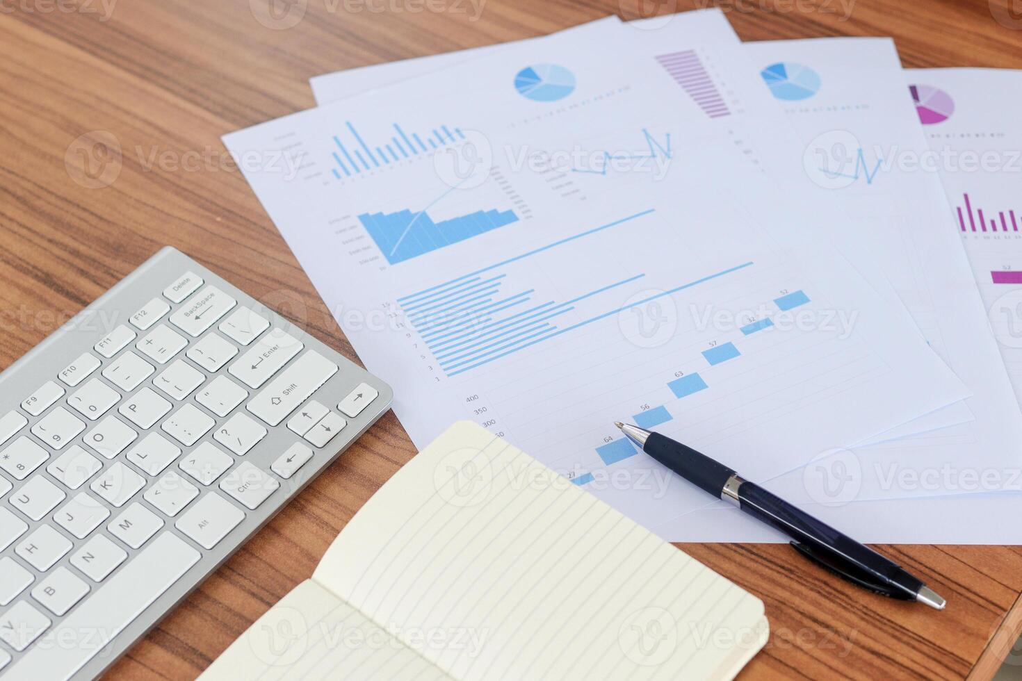 Close up of male freelance worker hand working on laptop and pointing with finger on analysis data with business graph and chart of information diagram on office desk in the morning photo