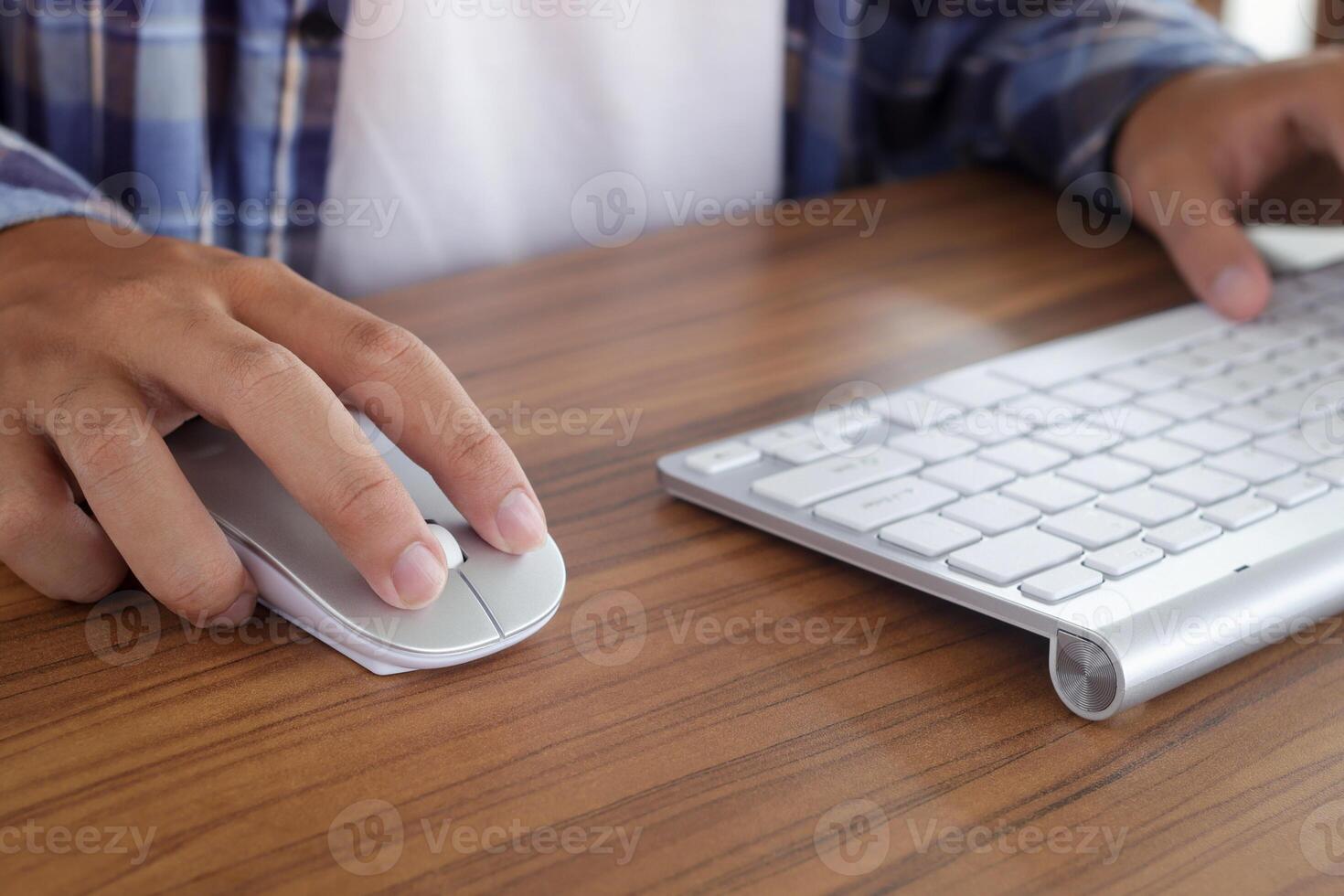 Close up of male hand using wireless keyboard and mouse in office desk. Casual working concept photo