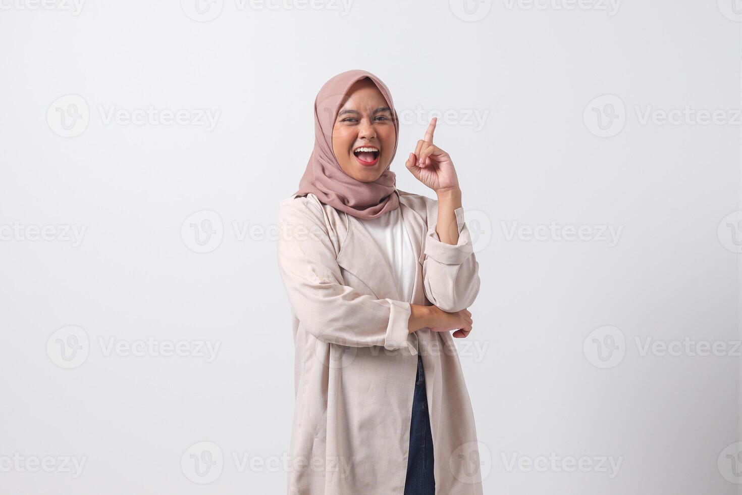 retrato de emocionado asiático hijab mujer en casual traje señalando arriba su dedo índice y recordando alguna cosa a hacer. mujer de negocios concepto. aislado imagen en blanco antecedentes foto