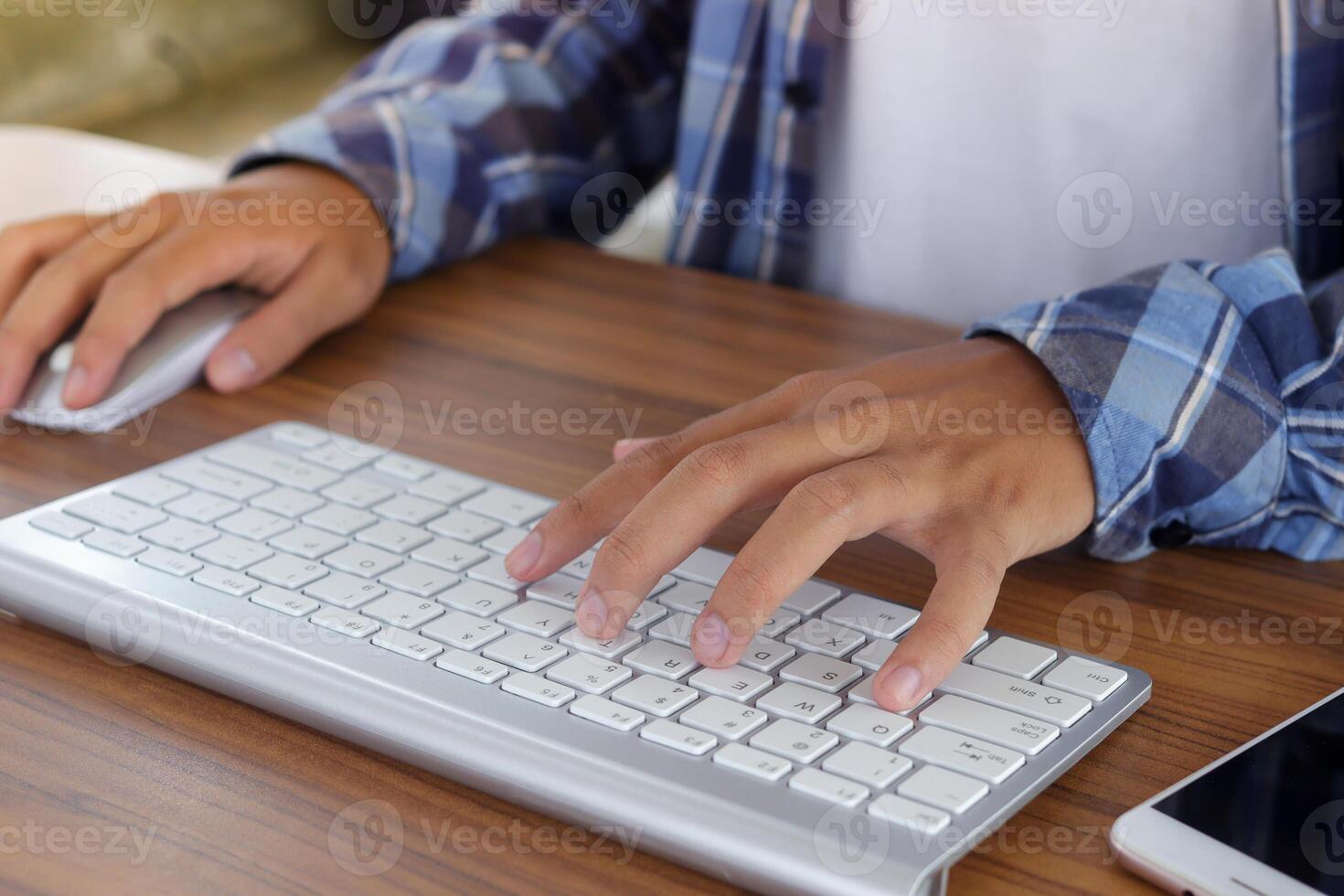 Close up of male hand using wireless keyboard and mouse in office desk. Casual working concept photo