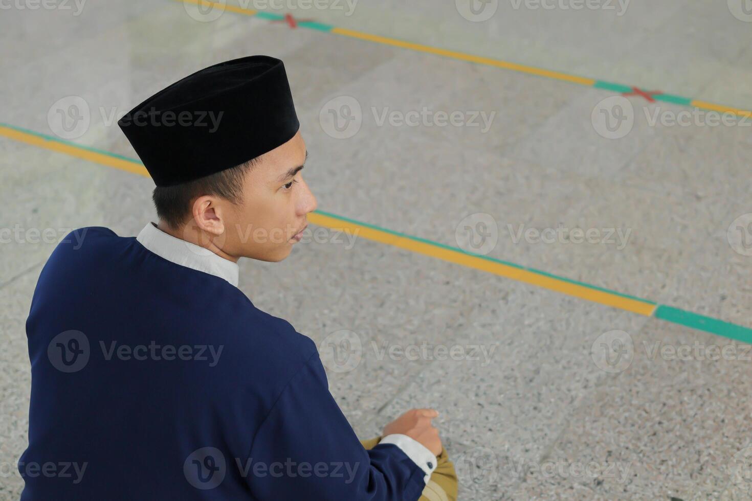 retrato de religioso asiático hombre en musulmán camisa Orando y haciendo salat o sholat en mezquita foto