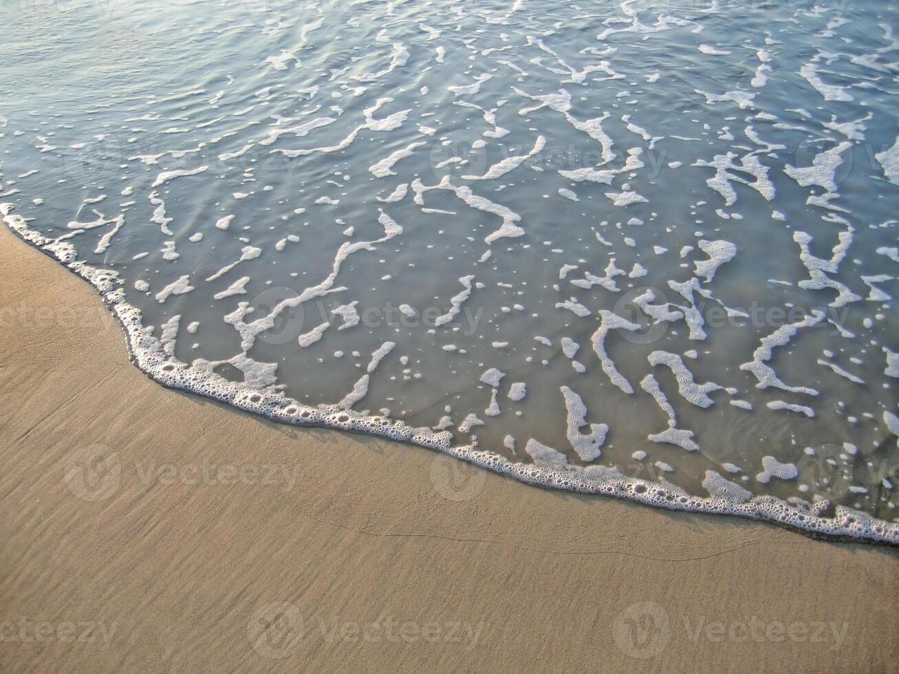 Sea wave on sand background photo