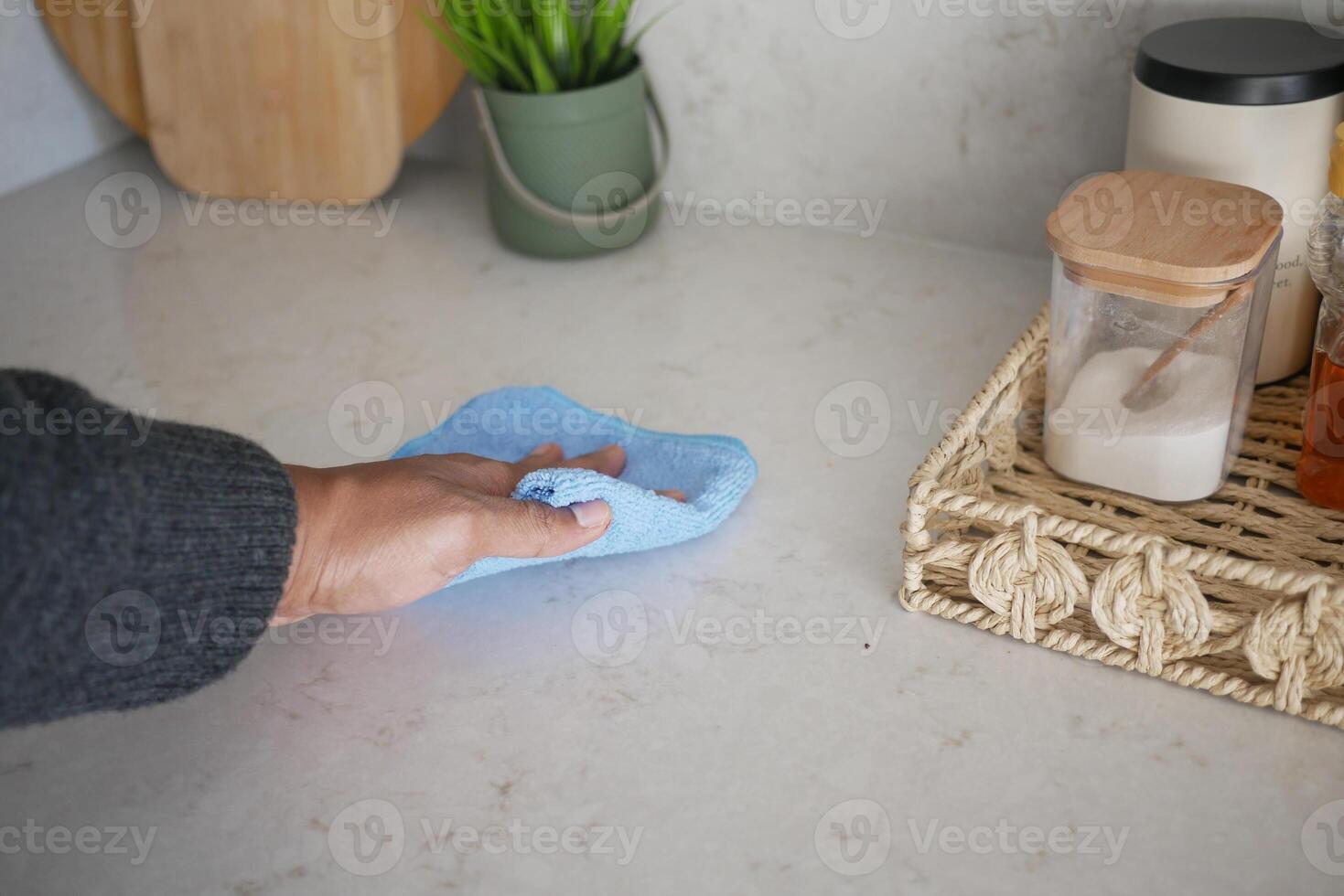 person hand cleaning kitchen table with cloth photo