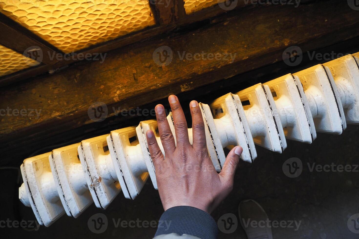 men warming hands near electric heater at home. photo