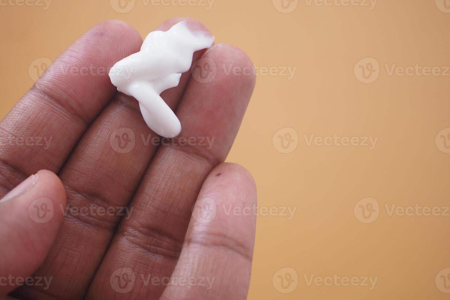 man applying beauty cream onto skin photo