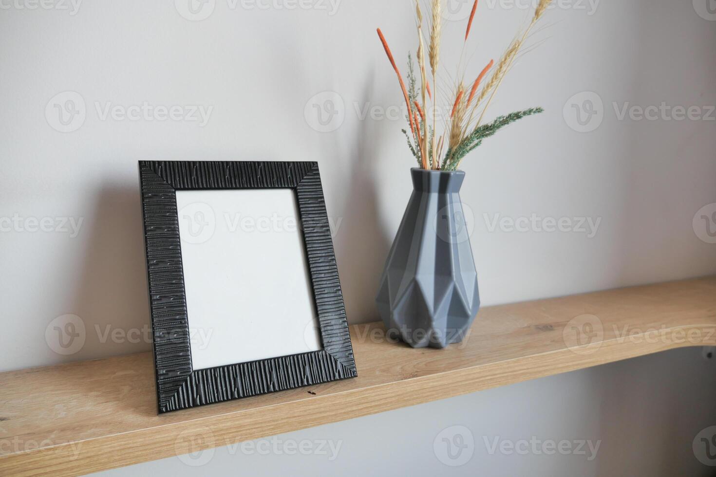 empty photo frame on table against white wall