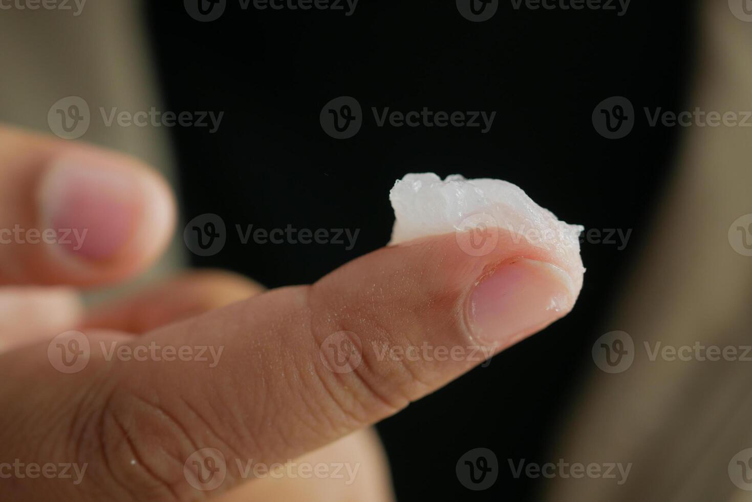 woman using petroleum jelly onto skin at home close up. photo