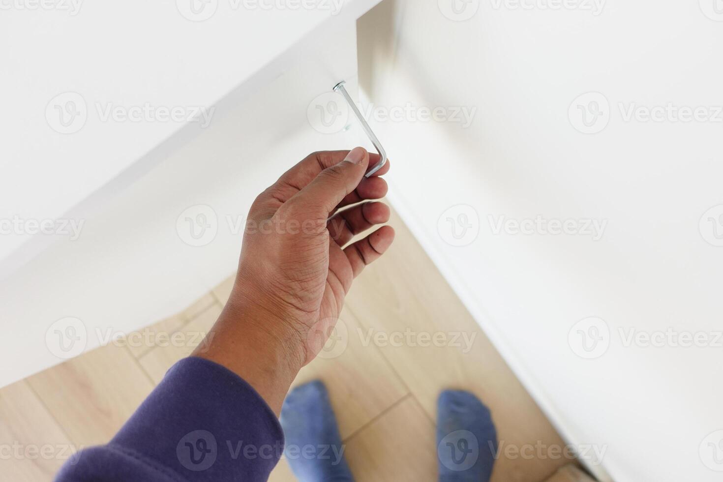 Using a wrench, theyre removing a screw from metal photo