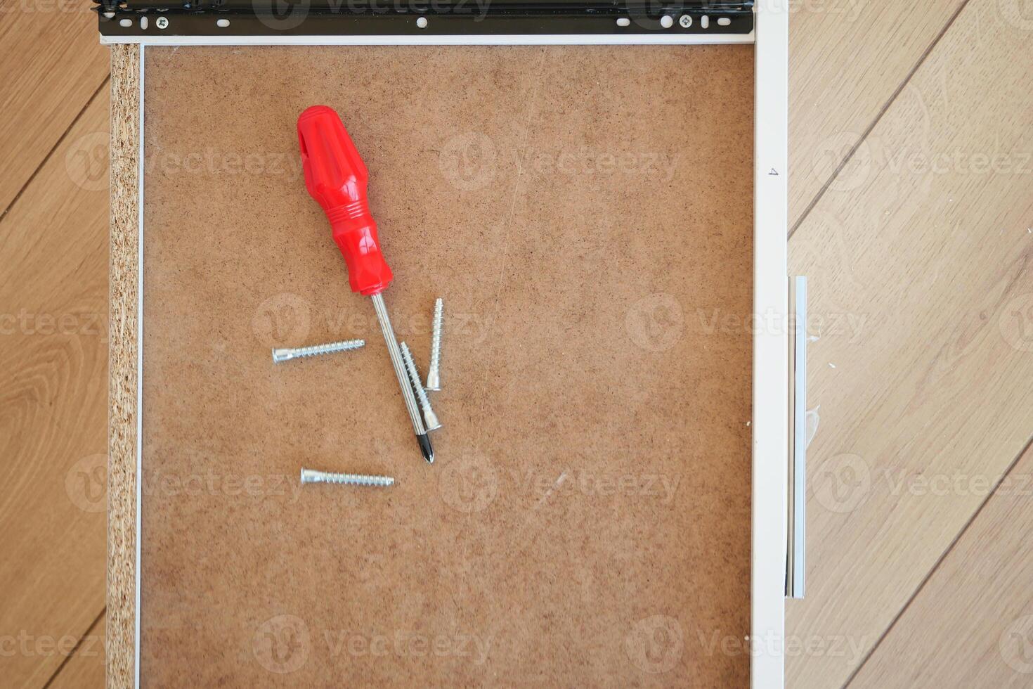 Wooden floor contains like screwdriver and nails in the drawer photo