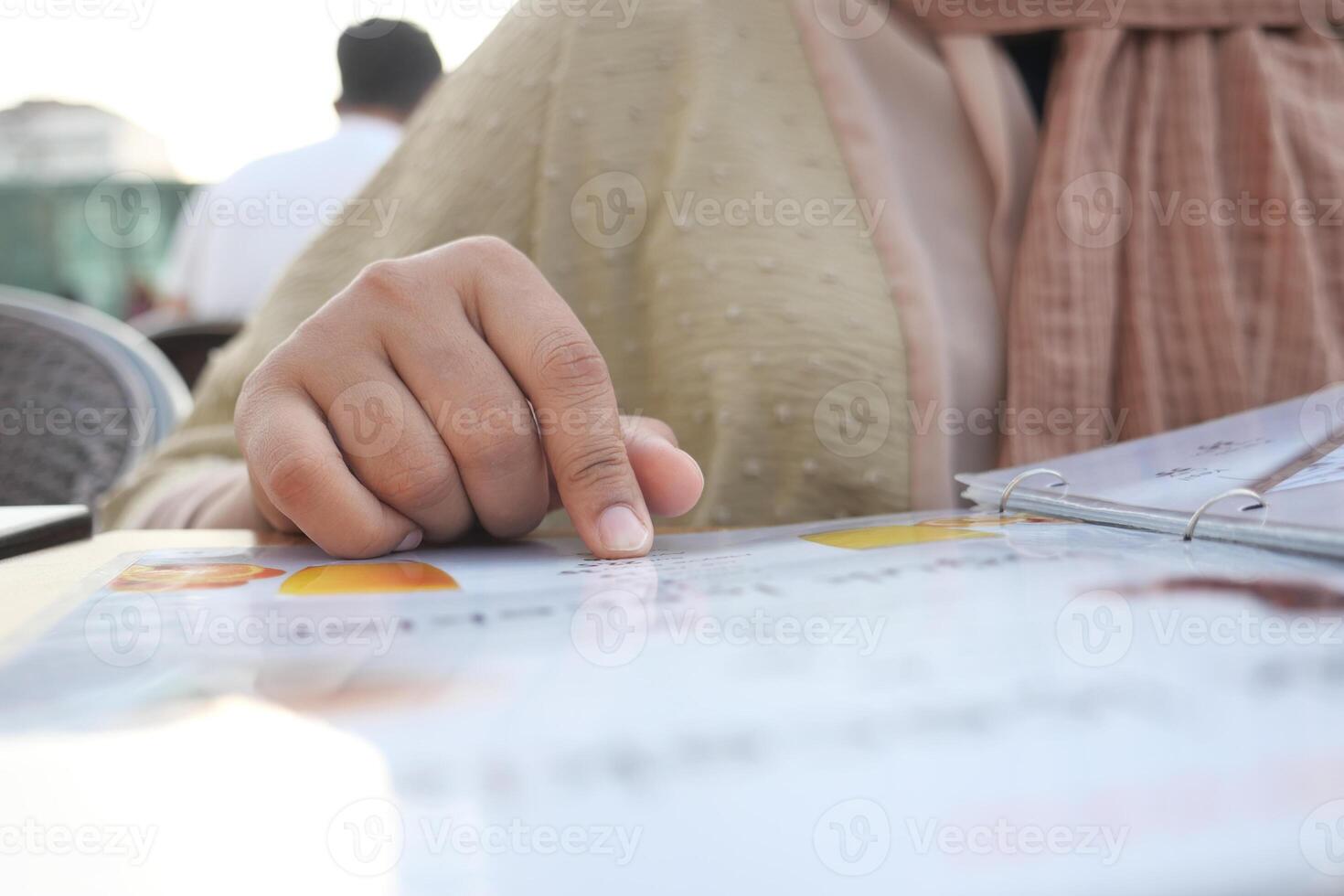 women hand reading a food menu at cafe. photo