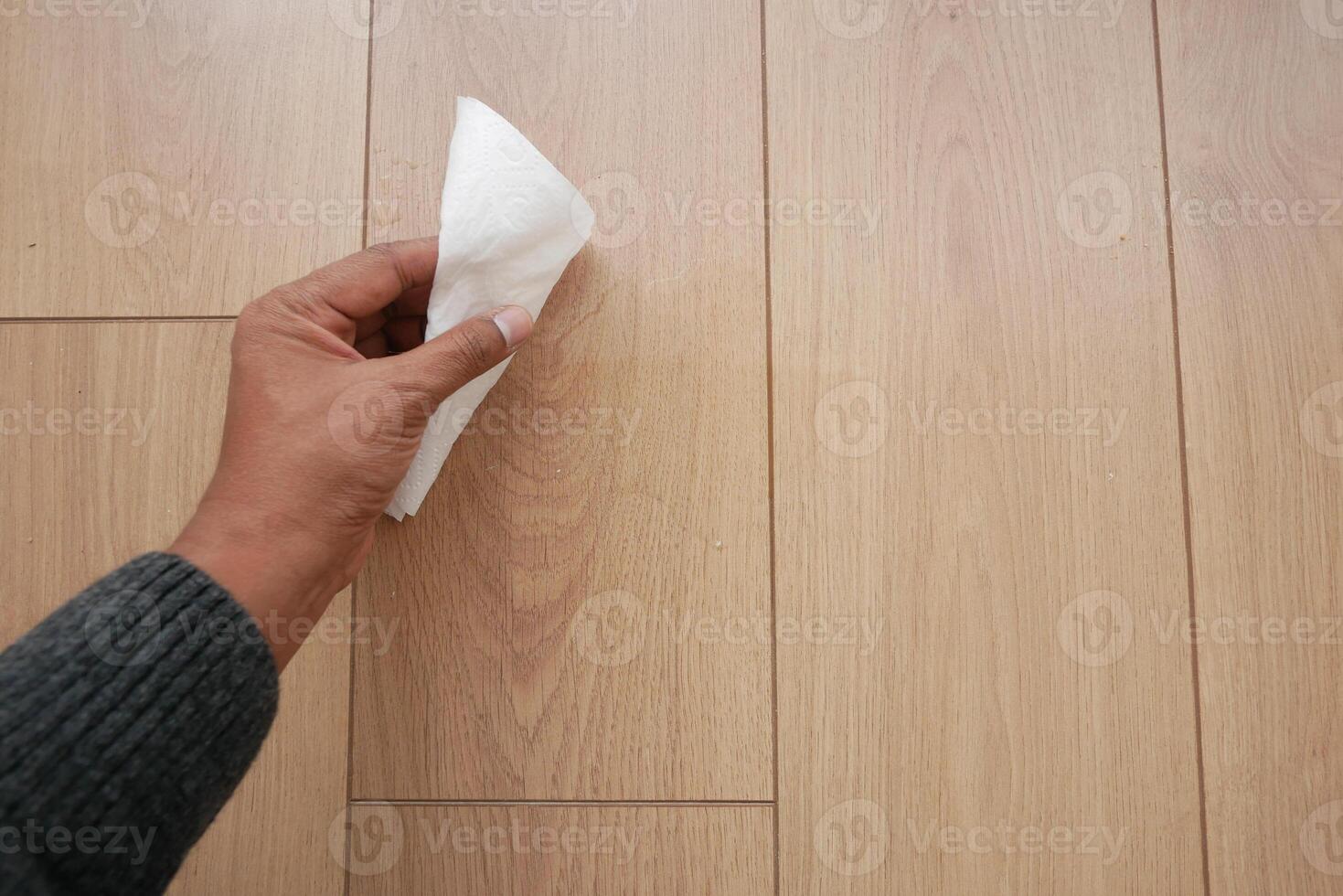 un del hombre mano Lavado el piso con un pañuelo de papel foto