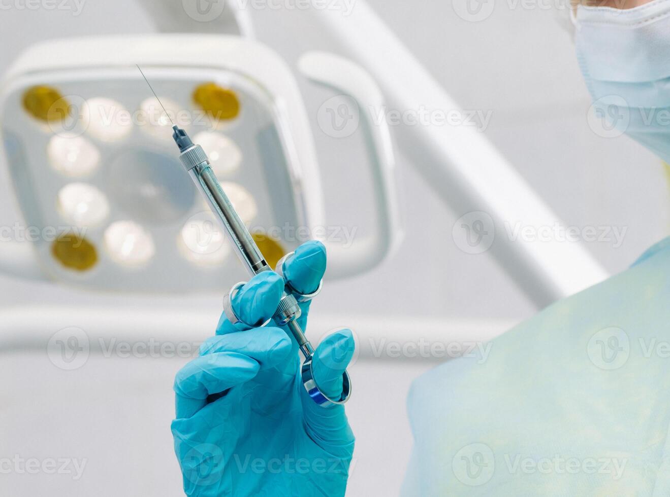 close-up of a dentist's hand holding an injection syringe for a patient in the office photo