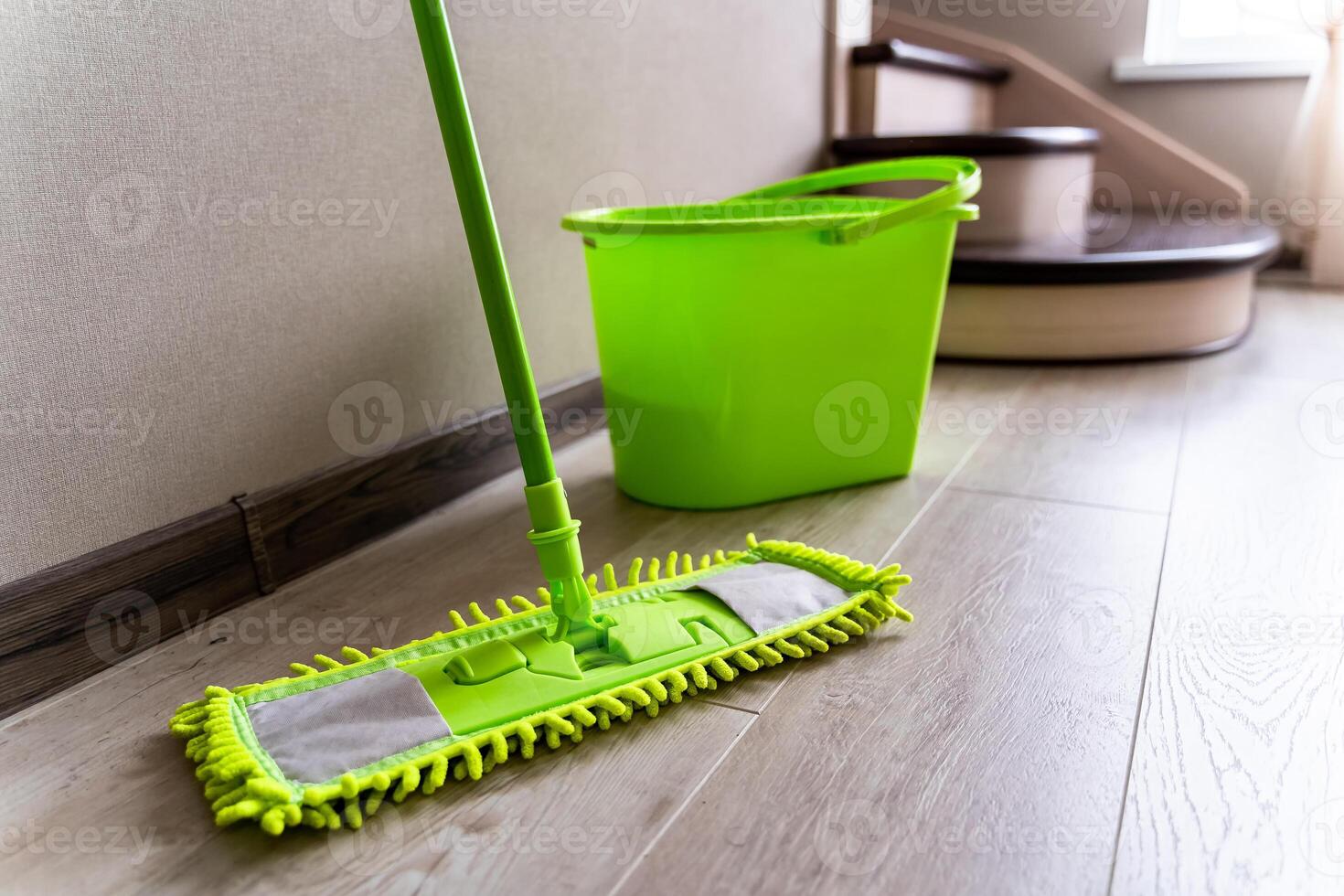 Mop with green microfiber rag, green plastic handle and bucket. Housekeeping concept. photo