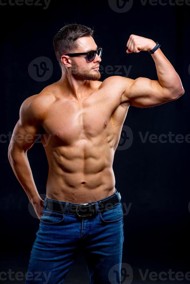 brutal fuerte atlético hombres bombeo arriba músculos. rutina de ejercicio y culturismo concepto. hermoso hombre con desnudo torso. aptitud modelo es posando vistiendo Gafas de sol. foto