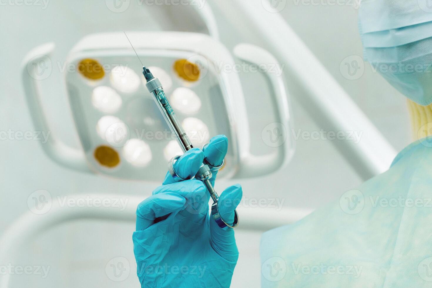 close-up of a dentist's hand holding an injection syringe for a patient in the office photo