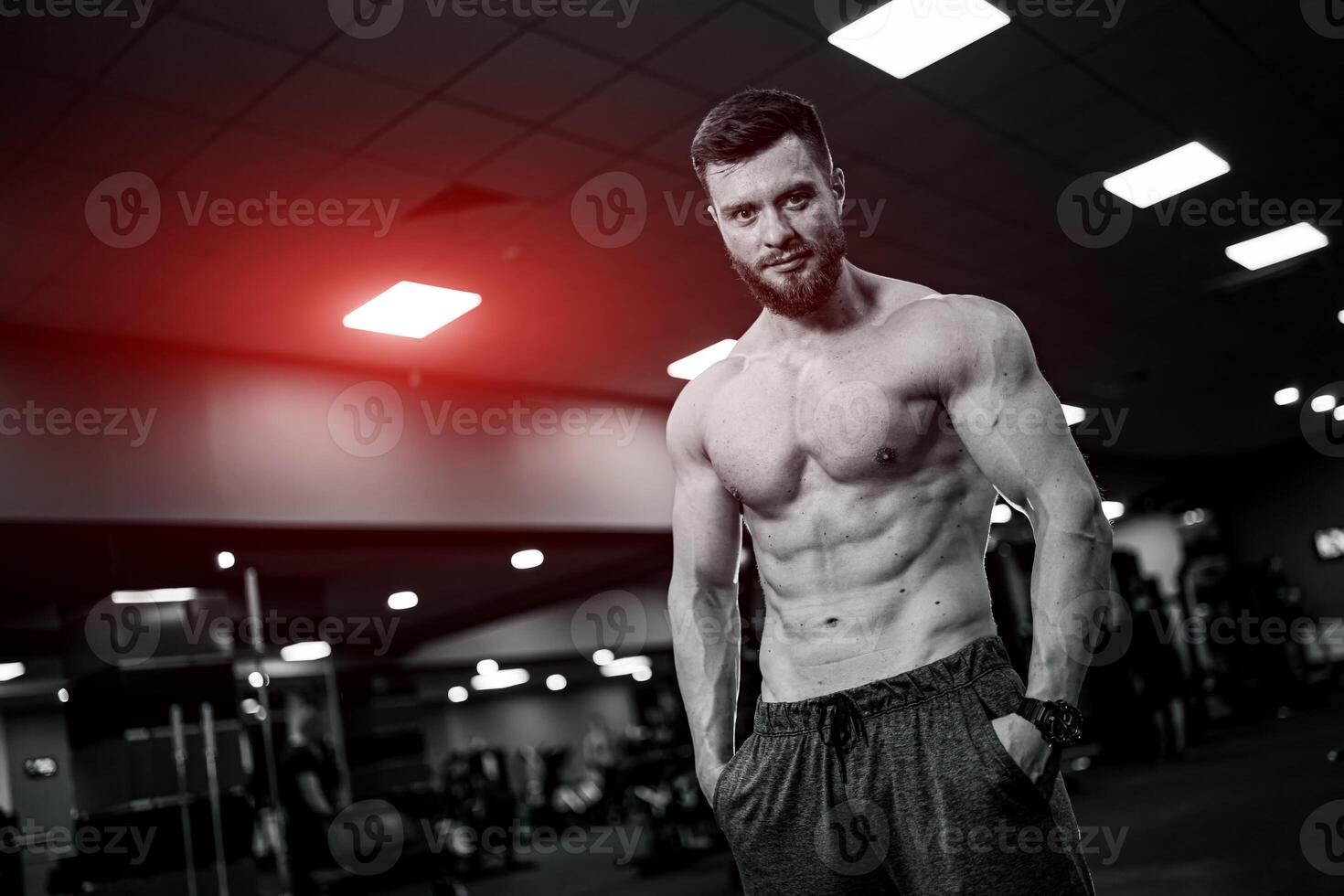 fuerte atleta masculino rutina de ejercicio en gimnasia. sin camisa muscular hombre teniendo descanso después difícil capacitación. foto