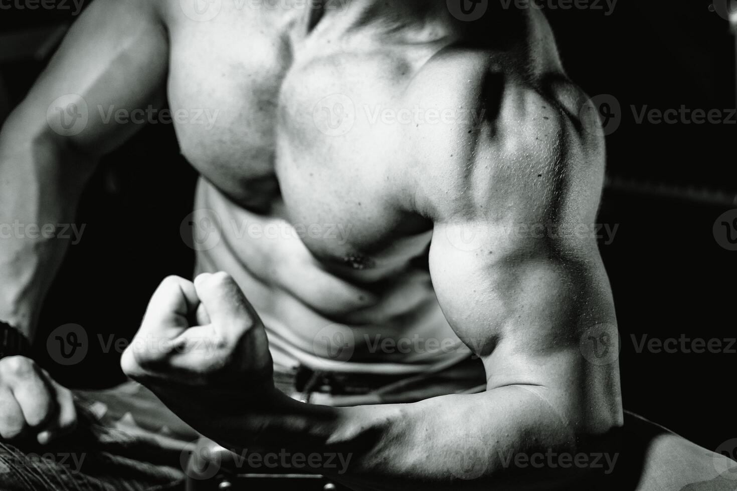 ajuste joven hombre bombeo músculos a un gimnasia. deporte, aptitud física, levantamiento de pesas, culturismo, capacitación, atleta, rutina de ejercicio ejercicios concepto. ver desde el lado foto