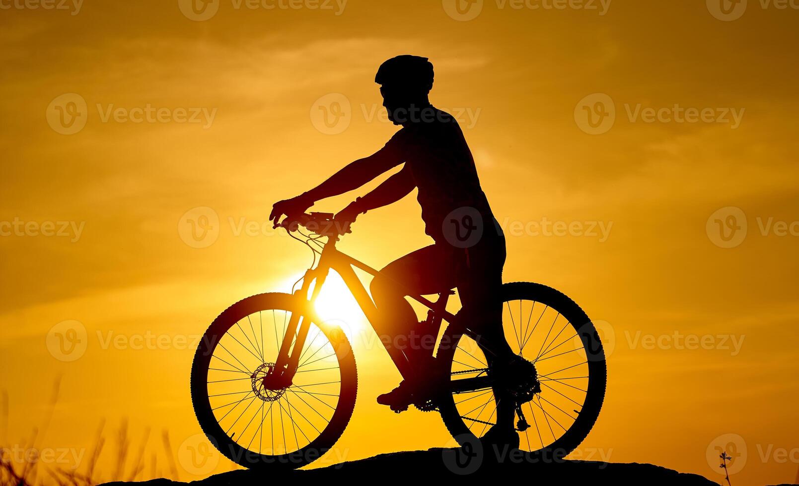 Silhouette of the cyclist riding on a sports bike at sunset. Active lifestyle concept. photo