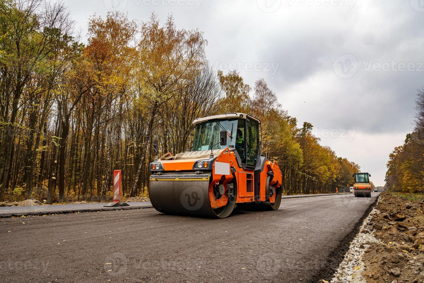 Road repair, compactor lays asphalt. Heavy special machines. Asphalt paver in operation. Side view. Closeup. photo