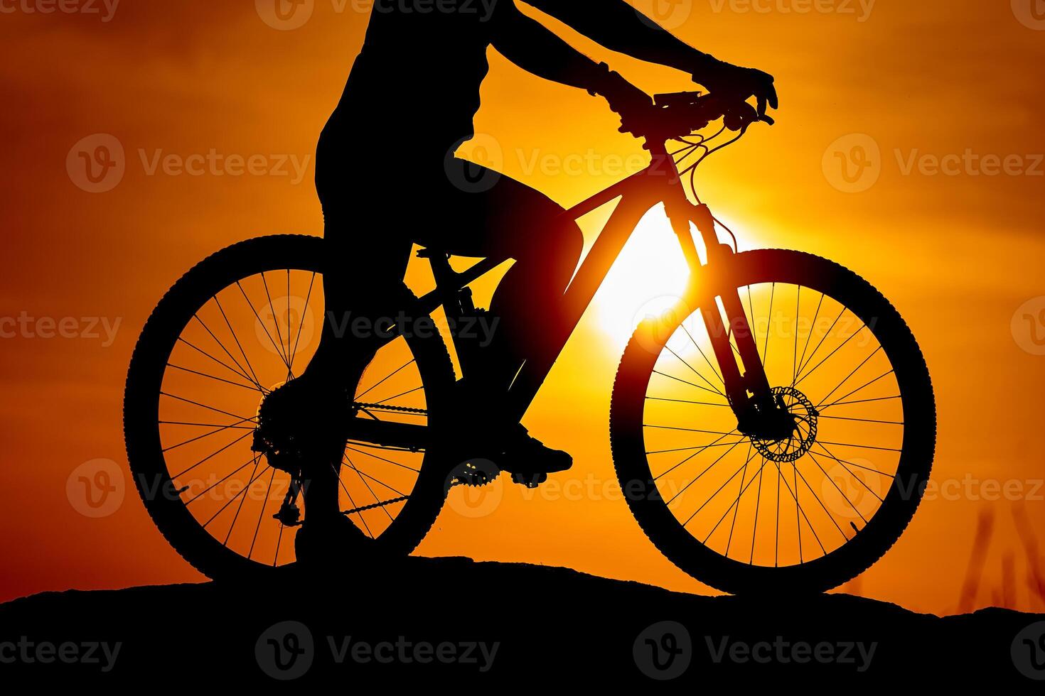 Silhouette of a bike with a man on sky background on sunset. Detailed photo. Closeup photo