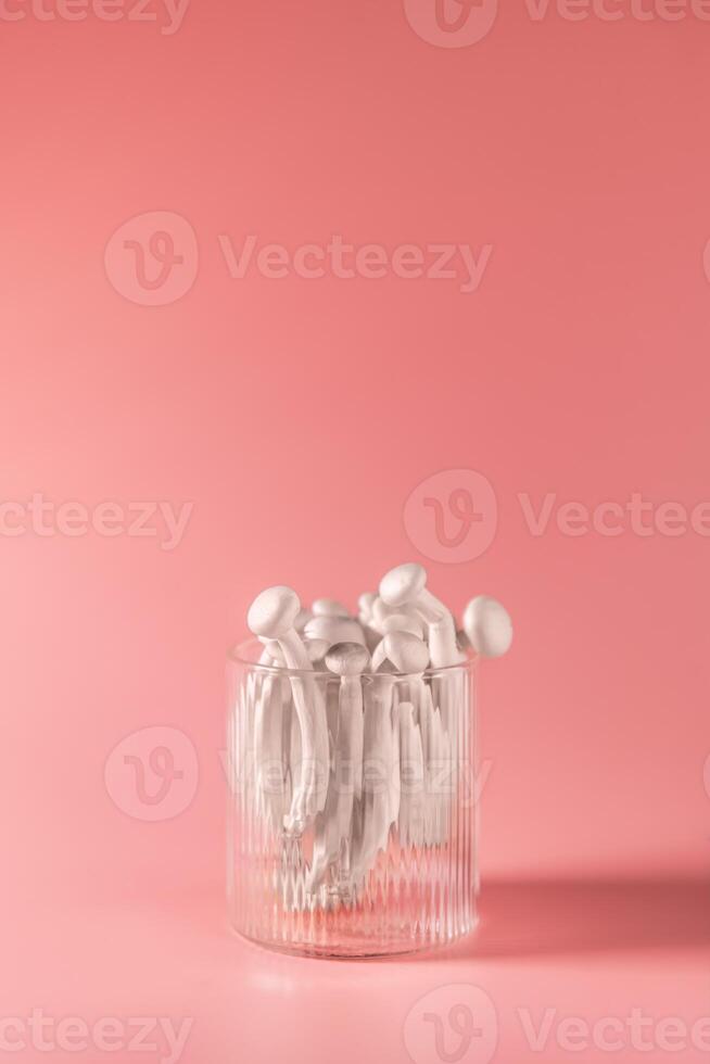 shimeji mushrooms in glass, on pink background photo